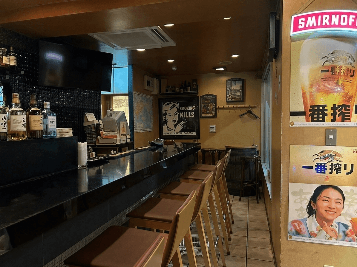 カウンター席とボトルが並ぶ落ち着いたバーの店内